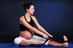 美丽的怀孕了年轻的女人练习瑜伽