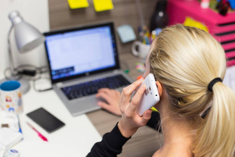 女企业家会说话的移动电话色彩斑斓的现代有创意的工作环境
