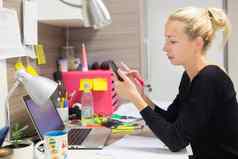 女企业家发短信移动电话色彩斑斓的现代有创意的工作环境