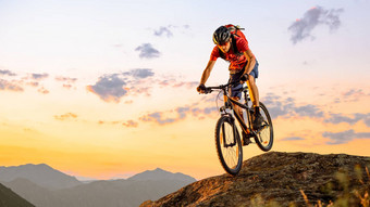 骑自行车的人红色的骑自行车岩石日落极端的体育运动复古骑自行车概念