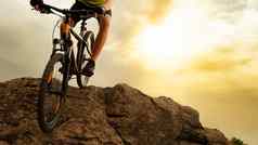 骑自行车的人骑山自行车岩石日落极端的体育运动复古骑自行车概念