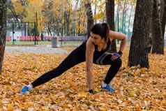 哈巴罗夫斯克俄罗斯10月有吸引力的女人体育衣服体育练习自然日落黑龙江河爱体操揉腿活跃的年轻的女孩订婚了体育领导健康的生活方式