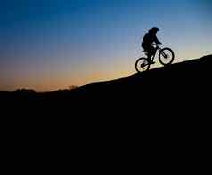 骑自行车的人骑自行车岩石小道日落极端的体育运动复古骑自行车概念