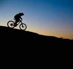 骑自行车的人骑自行车岩石小道日落极端的体育运动复古骑自行车概念