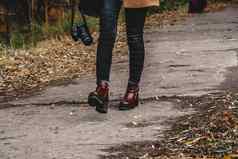 腿年轻的女人秋天公园鞋子单反
