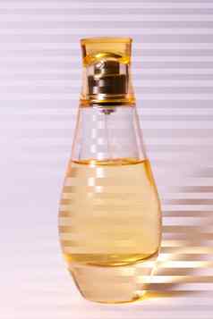 温暖的黄色的颜色玻璃香水瓶紫白相间背景照片条纹