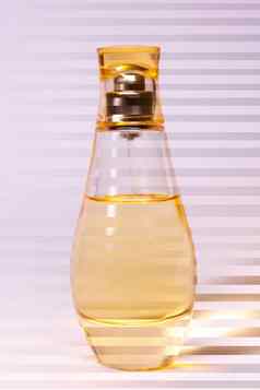 温暖的黄色的颜色玻璃香水瓶紫白相间背景照片条纹