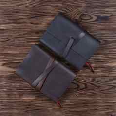 黑色的棕色（的）手工制作的皮革笔记本封面笔记本电脑木背景股票照片奢侈品业务配件视图