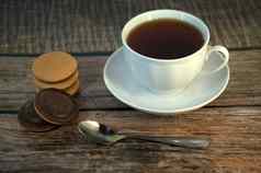 杯黑色的茶瓷飞碟勺子堆栈海绵饼干巧克力谎言木表格