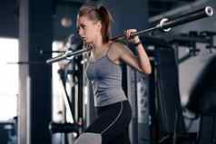 有吸引力的年轻的体育女人弓步杠铃健身房健身健康的生活方式