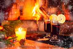 眼镜加香料的热酒蜡烛冷杉分支机构装饰木表格背景燃烧壁炉框架白霜雪花浪漫的圣诞节概念