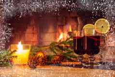 眼镜加香料的热酒蜡烛冷杉分支机构装饰木表格背景燃烧壁炉框架白霜雪花浪漫的圣诞节概念