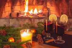 眼镜加香料的热酒蜡烛冷杉分支机构装饰木表格背景燃烧壁炉浪漫的圣诞节概念