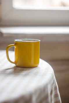 黄色的杯咖啡茶站明亮的表格阳光明媚的