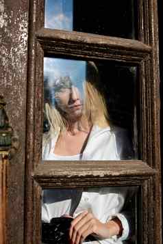 金发女郎女人站木门口木通过年轻的女人现代肖像