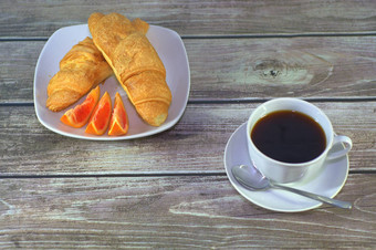 羊角面包橙色片板杯黑色的咖啡<strong>飞碟</strong>勺子表格特写镜头