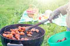 夏季野餐院子里烹饪鸡翅膀轮烧烤关闭