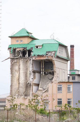 视图部分倒塌砖工业建筑绿色金属屋顶光天空工业筒仓建筑