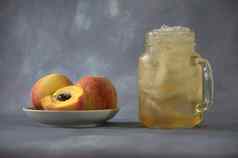 成熟的多汁的桃子陶瓷板杯子桃子汁冰灰色的摘要背景特写镜头