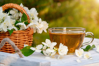 篮子花山梅花被称为茉莉花模拟橙色杯香茉莉花茶白色木托盘在户外夏天Copyspace