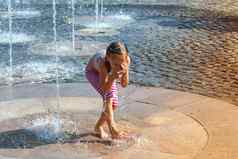 女孩阳光明媚的温暖的一天玩水喷泉女孩幸福的浅清洁水城市喷泉温暖的明亮的夏天一天