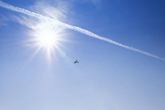 蓝色的天空背景蓝色的天空明亮的太阳飞机飞行飞机飞行天空背景明亮的日落基本背景设计