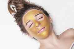 美丽的女孩化妆品面具脸金颜色特写镜头免费的空间女人黄金面具美丽的模型删除金面部皮肤化妆品美护肤品