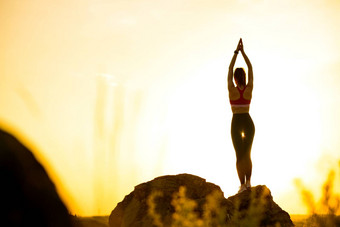 女人伸展运动户外温暖的锻炼日落体育运动健康的活跃的生命系统概念