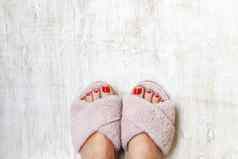 女腿红色的指甲首页皮毛毛茸茸的粉红色的拖鞋光木背景平躺前视图概念舒适的明亮的女孩房子