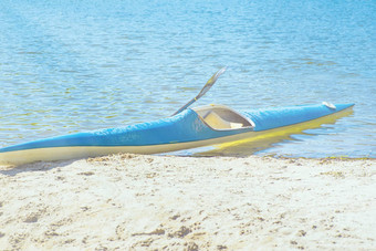 皮划艇概念皮艇海滩皮艇蓝色的黄色的船河银行夏天阳光明媚的一天皮艇体育运动