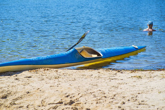 皮划艇概念皮艇海滩皮艇蓝色的黄色的船河银行夏天阳光明媚的一天皮艇体育运动