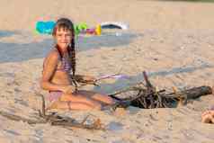 女孩休息时间柴篝火桑迪海滩看起来框架