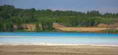 湖美丽的水苍白的蓝色的颜色包围松森林