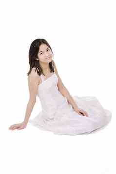 年轻的十几岁的女孩白色衣服礼服孤立的坐着地板上