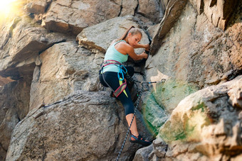 美丽的女人攀爬岩石山冒险极端的体育运动概念