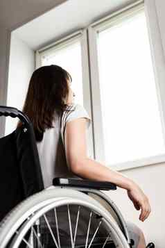 无效的禁用女人坐着轮椅窗口日光