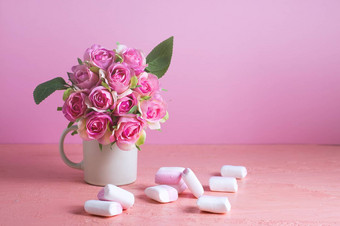 小白色粉红色的棉花糖分散苍白的粉红色的背景花瓶玫瑰的地方文本