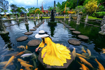 女人喂养色彩斑斓的<strong>鱼池</strong>塘提尔塔恒河水宫巴厘岛印尼