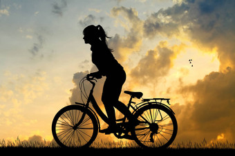 女孩骑自行车日落
