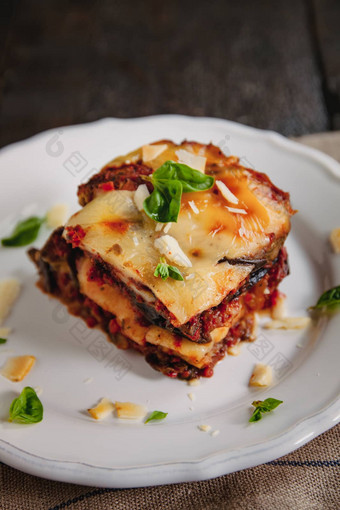 tradicional帕玛吉亚纳美拉烤茄子意大利西西里表妹。烤茄子奶酪西红柿香料白色板菜茄子木表格