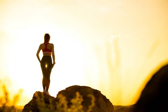 年轻的女人站岩石热美丽的夏天日落冒险健康的活跃的生命系统概念