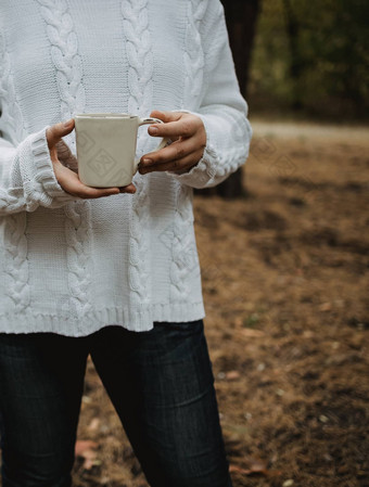 年轻的女人白色毛衣持有杯<strong>茶</strong>咖啡背景黄色的秋天叶子温暖的秋天<strong>大气</strong>软焦点复制空间