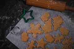 减少姜饼饼干形式圣诞节树明星男人。心生面团羊皮纸烘焙纸黑暗背景前视图保存空间