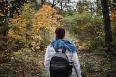 徒步旅行女人秋天森林背包客站林地秋天季节享受徒步旅行自然阳光明媚的一天