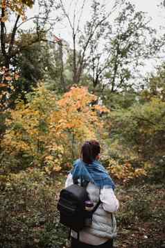 徒步旅行女人秋天森林背包客站林地秋天季节享受徒步旅行自然阳光明媚的一天