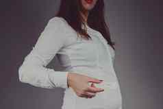年轻的女人检查怀孕测试积极的结果工作室