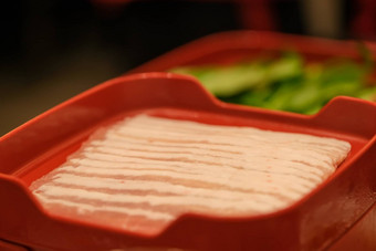 切片生猪肉肉孤立的红色的板背景前视图
