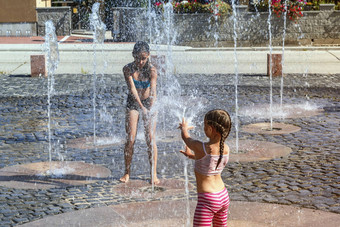 孩子们阳光明媚的温暖的一天玩水喷泉孩子们幸福的浅清洁水城市喷泉温暖的明亮的夏天一天