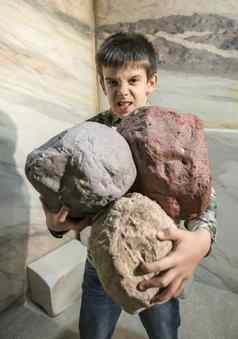 强大的孩子持有重石头