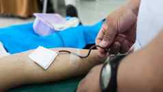 志愿者男人。给血捐赠交叉红色的组织。人血捐赠概念